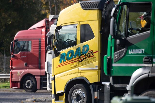 LKW stehen auf dem Parkplatz einer Rastanlage.