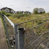 Eine Brachfläche in Bergkamen: Wiese mit einem Metallzaun umzäunt.
