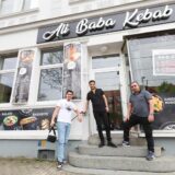 Adar Kaya und seine Familienmitglieder Mahsum und Ali stehen stolz vor ihrem Dönerladen.