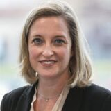 Heike Marzen von der Wirtschaftsförderung Dortmund schaut in die Kamera. Demonstranten setzen sich für die Brechtener Niederung ein.
