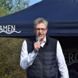 Bernd Schäfer steht unter einem Pavillon, der die Aufschrift „natürlich Bergkamen“ trägt.