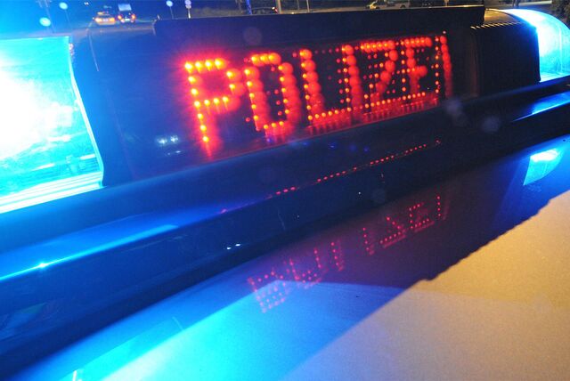 „Polizei“ Schriftzug auf Anzeigefeld eines Polizeiautos mit Blaulicht