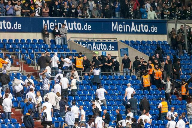 Schalker (weiße Shirts) und Frankfurter Fans prügeln sich nach einem Spiel auf der Tribüne.