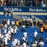 Schalker (weiße Shirts) und Frankfurter Fans prügeln sich nach einem Spiel auf der Tribüne.
