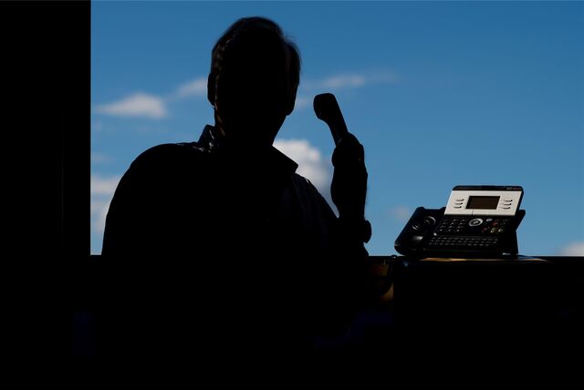 Die Silhouette eines Mannes, der am Telefon spricht, ist zu sehen.