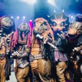 Die fünf Mitglieder der Band Heavysaurus stehen in ihren Kostümen auf der Bühne.