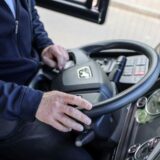 Hände eines Fahrers am Steuer eines Busses