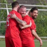 Nils Rataj, Steven Schnura und Ahmet Keske vom FC TuRa Bergkamen liegen sich in den Armen.