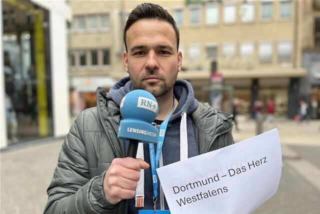 Martin Bytomski hält ein Mikrofon in der Hand.