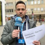 Martin Bytomski hält ein Mikrofon in der Hand.