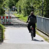Ein Fahrradfahrer fährt über die Sesekebrücke des Eilater Weges, hinter der Sperrschilder stehen.