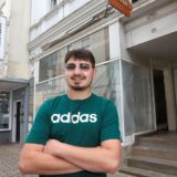 Ein Mann steht vor einem Laden.