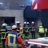 Viele Feuerwehrleute stehen am Sonntagabend vor einem Mehrfamilienhaus in Unna-Massen.