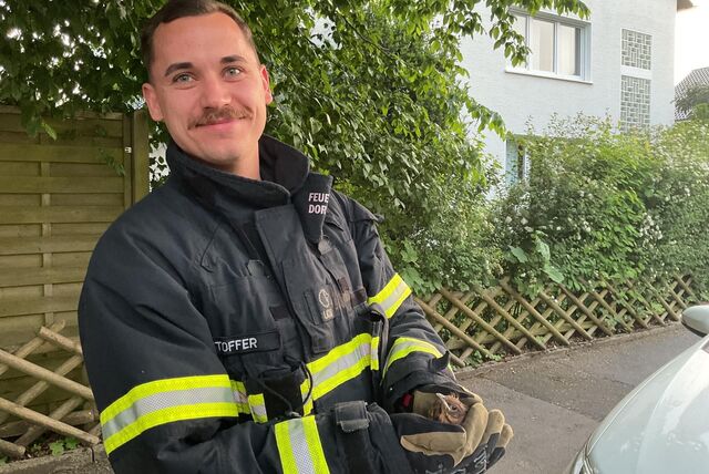 Zufrieden mit seinem Einsatz: Dieser Feuerwehrmann hält strahlend das gerettete Küken in den Händen.