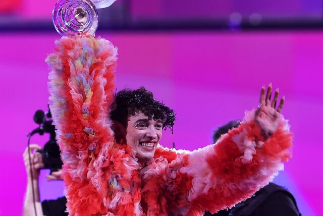 Nemo, Sieger des ESC 2024, steht auf der Bühne und reißt den Siegerpokal in die Höhe.