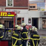 Bei einem Einsatz in Unna stehen mehrere Feuerwehrleute neben einem Feuerwehrfahrzeug auf der Bahnhofstraße.