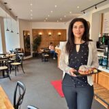 Caféleiterin Inci Arslantürk präsentiert eins der außergewöhnlich belegten Croissants in dem lichtdurchfluteten Café.
