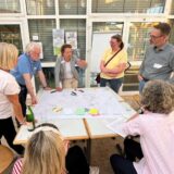 Bürger und Fachleute planen Königsborn um: Mit der Arbeit an Projekttischen begann im Bürgerforum jetzt „KRIS“. Auf dem Bild steht eine Gruppe um einen Arbeitstisch herum.