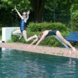 Kinder springen in ein Becken im Freibad Selm.