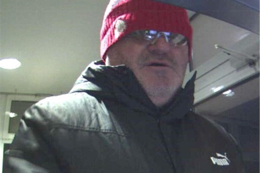 Tatverdächtiger hebt Geld mit einer Karte an einem Bankautomaten in Menden ab