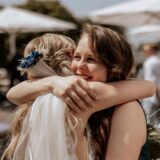 Braut und Hochzeitsplanerin umarmen sich.