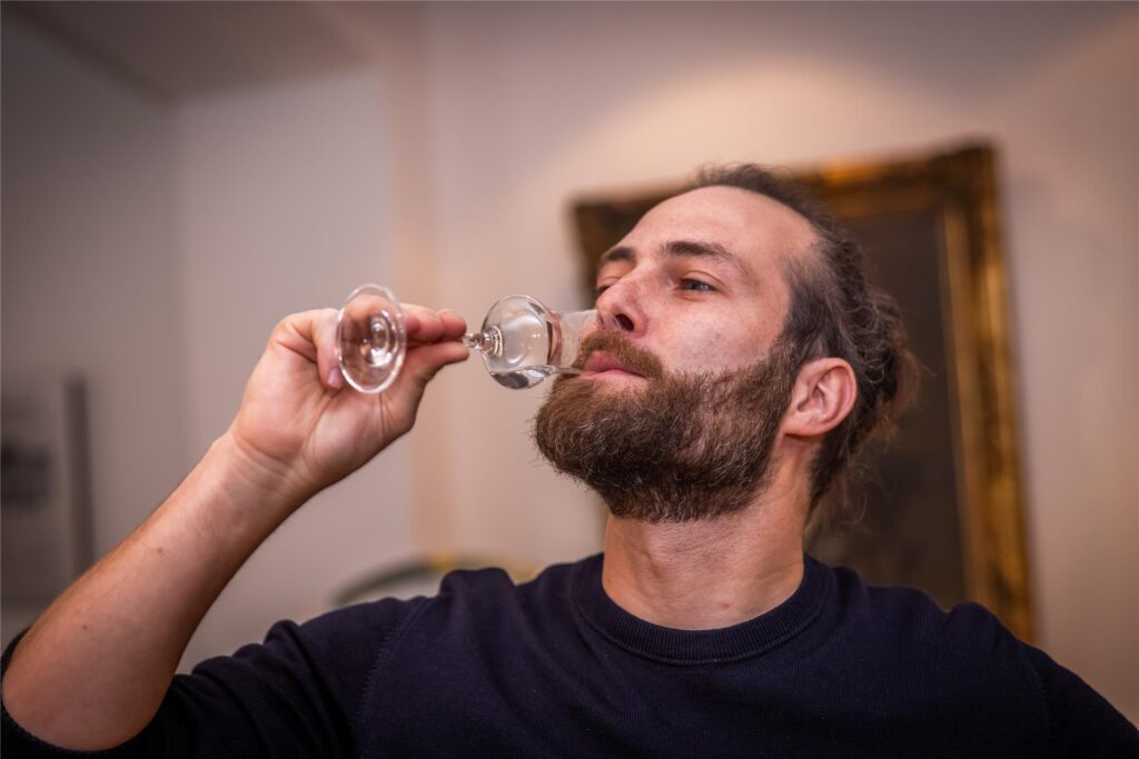 Felix Krämer kostet aus einem Glas.