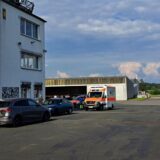Auf einem Flugplatzgelände steht ein Rettungswagen.