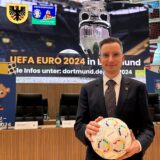 Der städtische EURO-Beauftragte Martin Sauer mit einem Fußball in den Händen und Plakaten zur Fußball-EM im Dortmunder Rathaus.