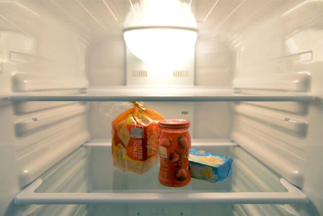 Ein Toastbrot, ein Glas Marmelade und ein Stück Butter liegen in einem Kühlschrank