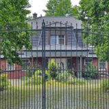Durch ein historisierendes Gittertor fällt der Blick auf das Hauptgebäude des Vogelparks in Unna-Uelzen, dem privaten Anwesen von Unternehmer Thomas Wiese.