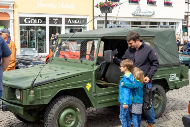 Ein Mann steht neben seinem Auto.