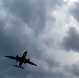 Gewitterwolken türmen sich über einem Flugzeug auf.