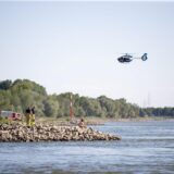 Aus einem Hubschrauber und vom Ufer aus suchen Einsatzkräfte nach einem Schwimmer, der im Rhein von einem Sog erfasst und mitgerissen wurde.