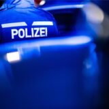 Ein Polizist mit Jacke. Auf dem Rücken steht groß „Polizei“.