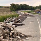 Am Rand der Türkenstraße zwischen Unna und Billmerich lagert Bauschutt. Im Hintergrund sind Baumaschinen und Absperrungen