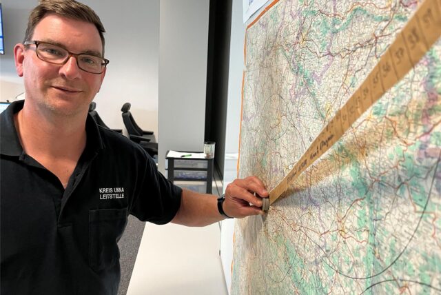 Carsten Kreutzer ist Lagedienstführer in der Kreisleitstelle für Feuerwehr und Rettungsdienst an der Florianstraße in Unna. Hier steht er an einer klassischen Landkarte, die – neben den digitalen Programmen – eine schnelle Berechnung der Flugdauer von Rettungshubschraubern zum Einsatzort ermöglicht.