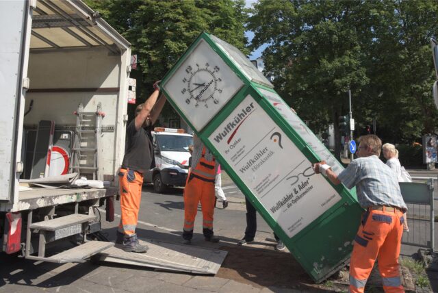 An der Morgenstraße/Ecke Ostring in Unna bauen im Jahr 2017 Arbeiter eine große Standuhr ab und heben sie in einen Lastwagen