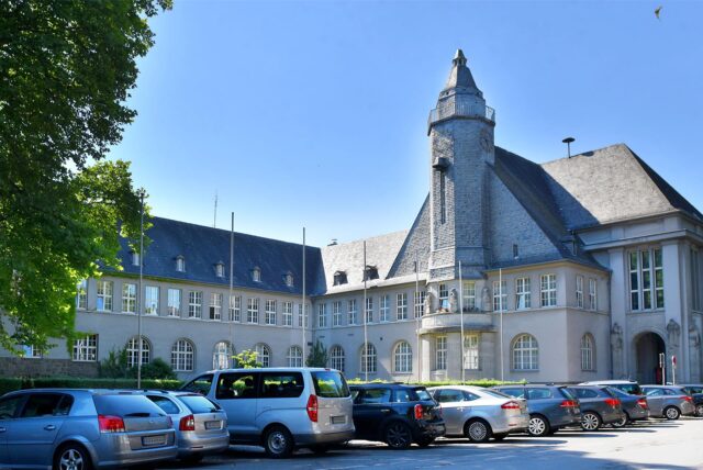 Das Rathaus in Schwerte mit einigen Autos auf dem Parkplatz.
