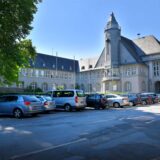 Das Rathaus in Schwerte mit einigen Autos auf dem Parkplatz.