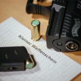 Ein kleiner Waffenschein liegt zwischen einer Schreckschuss-Pistole «Walther P22», einem Magazin und einer Knallpatrone.