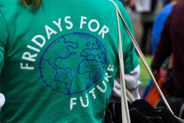 Eine Frau demonstriert in einem grünen T-Shirt mit der Aufschrift «Friday for Future».