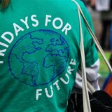 Eine Frau demonstriert in einem grünen T-Shirt mit der Aufschrift «Friday for Future».