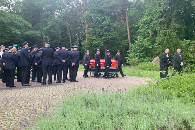 Ein roter Sarg, geleitet von Feuerwehrkameraden. Der langjährige Weddinghofener Einheitsführer Peter Budde wurde am 31.5.2024 auf den Parkfriedhof in Bergkamen beigesetzt.
