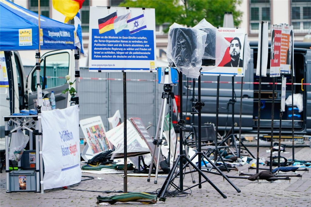 Plakate eines Standes liegen auf dem Marktplatz auf dem Boden. Plakate eines Standes liegen auf dem Marktplatz auf dem Boden.