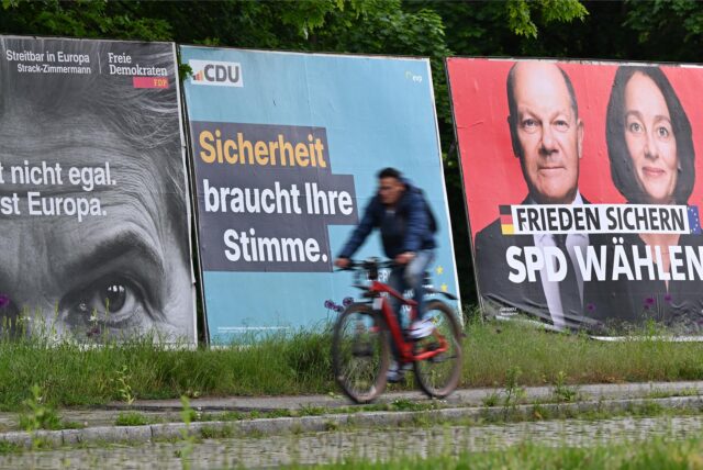 Ein Radfahrer fährt an Großplakaten von FDP, CDU, SPD und Freien Wählern zur Europawahl vorbei.