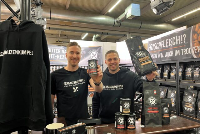 Die Gründer Maximilian Tillmann und Daniel Bendas stehen bei der Messe „Dogs & fun“ in der Westfalenhalle am Messestand von „Schnauzenkumpel“.
