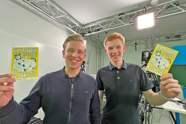 JU-Kreisvorsitzender Tim Stohlmann aus Werne (l.) und Juso-Kreisvorsitzender Alexander Höll aus Bergkamen halten Reklamepostkarten für die Europawahl 2024 in die Luft.