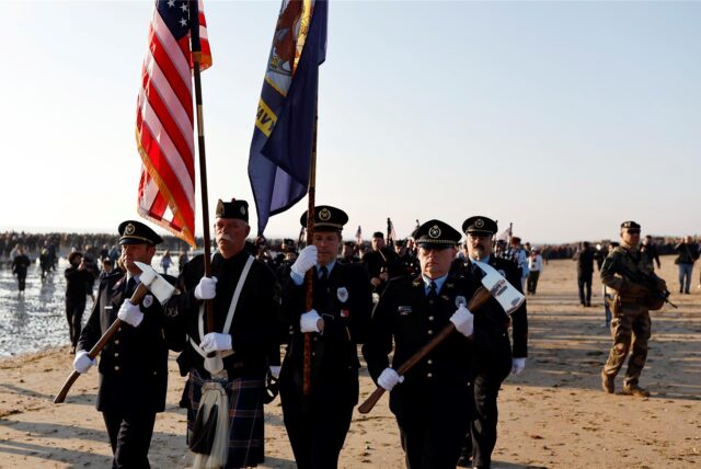 Teilnehmer marschieren während einer Zeremonie am Utah Beach bei Saint-Martin-de-Vareville in der Normandie.