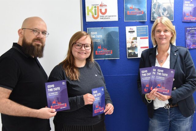 Kirsten Jung, Nele Blase und Maik Stiens von der Stadt Schwerte halten Flyer für das Ruhrsight-Festival in Schwerte am 23. August 2024 in die Kamera.