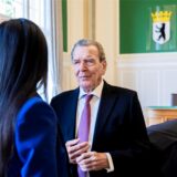 Altkanzler Gerhard Schröder (SPD, r-l), sein Rechtsanwalt Michael Nagel (verdeckt) und seine Ehefrau Soyeon Schröder-Kim (von hinten) unterhalten sich im Oberverwaltungsgericht (OVG) Berlin-Brandenburg nach der mündlichen Verhandlung im Prozess um den Verlust seines Büros im Bundestag.